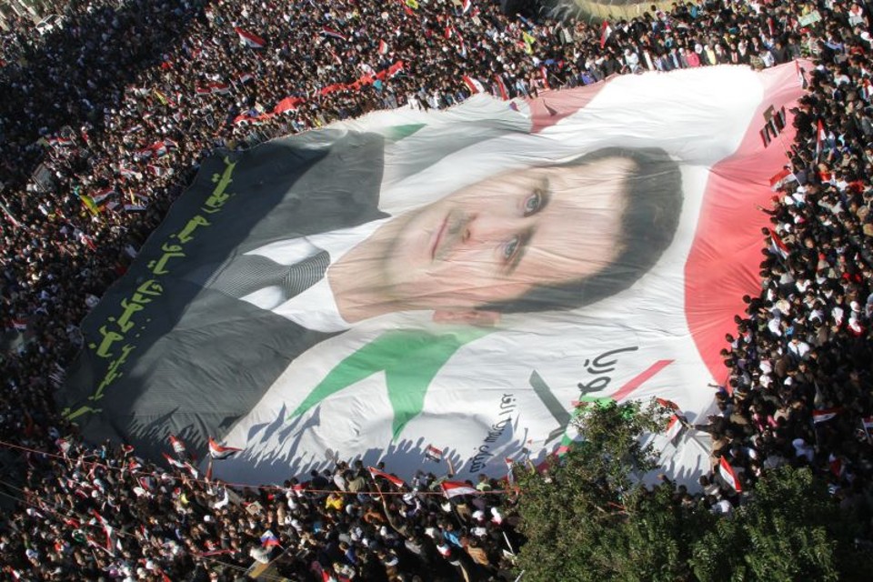 Manifestantes carregam imagem do presidente Bashar al-Assad, durante manifestação contra as sanções impostas pela Liga Árabe à Síria. Por outro lado, as forças repressoras de Assad teriam matado ao menos 10 pessoas nesta segunda-feira (28) | Louai Beshara/AFP