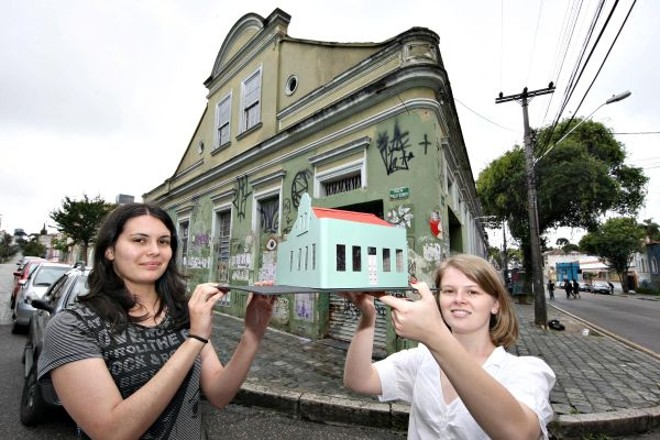As estudantes Ana Emília Kummer e Antonella Gobbo seguram a maquete da casa da Trajano Reis que pesquisaram |