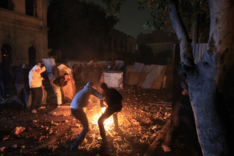 Manifestantes egípcios se escondem durante confronto | AFP PHOTO/MOHAMMED ABED