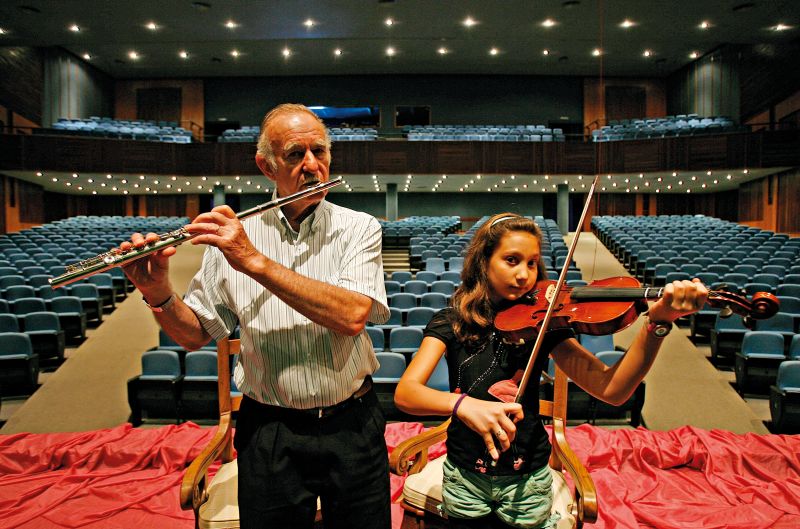 O flautista Elemar Schweizer, 72 anos, e a violinista Chiara Marella, 10: Orquestra de Câmara de Toledo reúne músicos de diferentes idades e classes sociais | Hugo Harada/ Gazeta do Povo