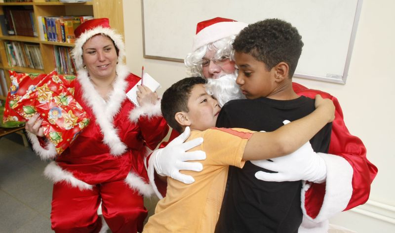 A repórter Aline Peres observa o abraço apertado que meninos do Bolsão Sabará, na CIC, dão no Papai Noel da Gazeta do Povo | Daniel Castellano/ Gazeta do Povo