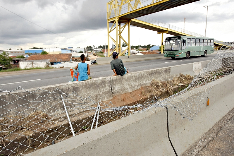 Flagrante do perigo na BR-116, na Vila Zumbi: de dia, pessoas se arriscam para chegar mais rapidamente ao outro lado; de noite o problema é o pedágio | Antônio More/ Gazeta do Povo