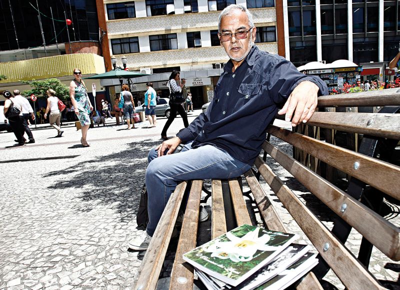 Estrategicamente posicionado em um banco em frente à Galeria Tijucas, na Rua XV, o escritor Cândido Miranda deixa seus livros para quem quiser pegar | Priscila Forone/ Gazeta do Povo