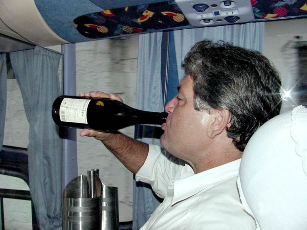 Momento de comemoração: em foto inédita, após o jogo com o São Caetano, ainda dentro do ônibus da delegação, Geninho vira no gargalo um generoso gole de vinho