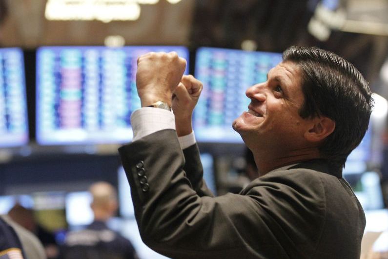 Operador da Bolsa de Nova York comemora após o fim do pregão: ação de bancos centrais e notícias da China fizeram o Dow Jones subir 4,23% ontem | Brendan McDermid/Reuters