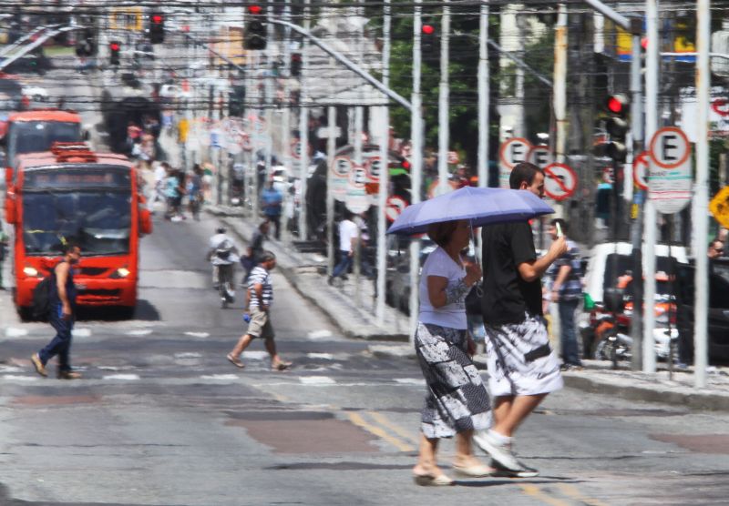 Ontem, às vésperas do verão, os efeitos da nova estação já podiam ser sentidos nas ruas de Curitiba. Sombrinha e sorvete para contornar o calor | Daniel Castellano/ Gazeta do Povo