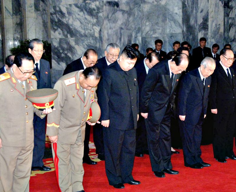 Kim Jong-un (centro), filho do ex-ditador da Coreia do Norte, Kim Jong-il, e membros do Partido Comunista e militares prestam condolências em velório do líder morto no fim de semana | KCNA/AFP