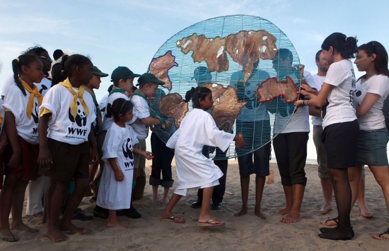Membros da ONG WWF seguram uma "Terra" simbólica feita por crianças de Durban, onde ocorre a Conferência da ONU sobre o clima | Rajesh Jantilal/AFP