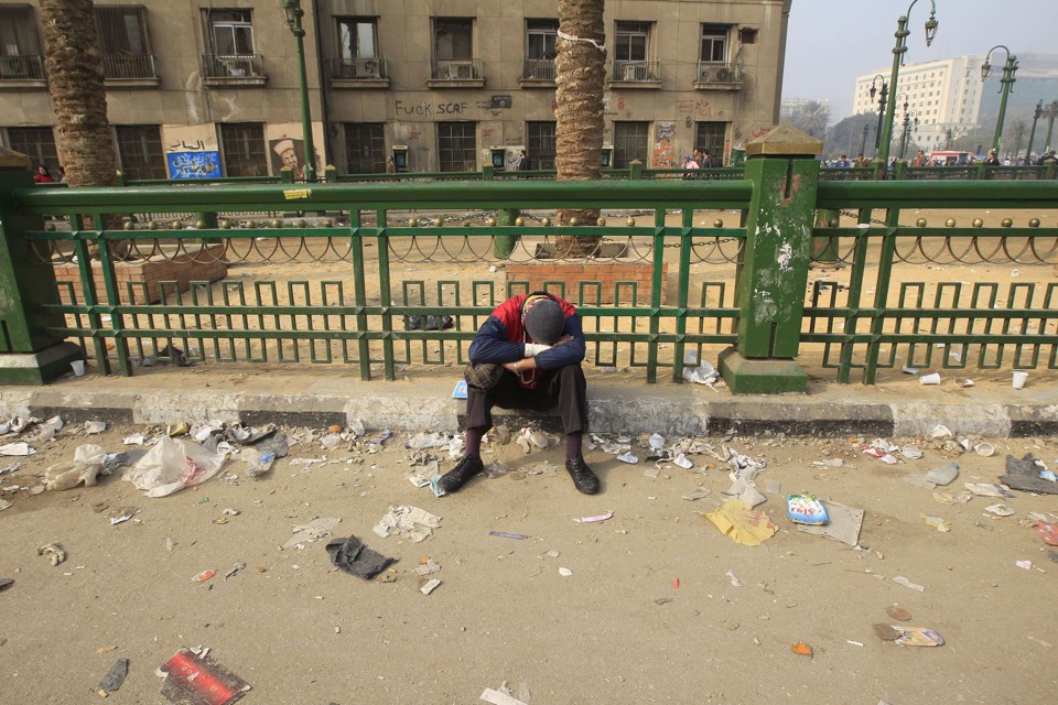 Protestante egípcio descansa em rua suja na praça Tahrir, no Cairo, após dia de confrontos com a polícia | AFP PHOTO/MOHAMMED ABED