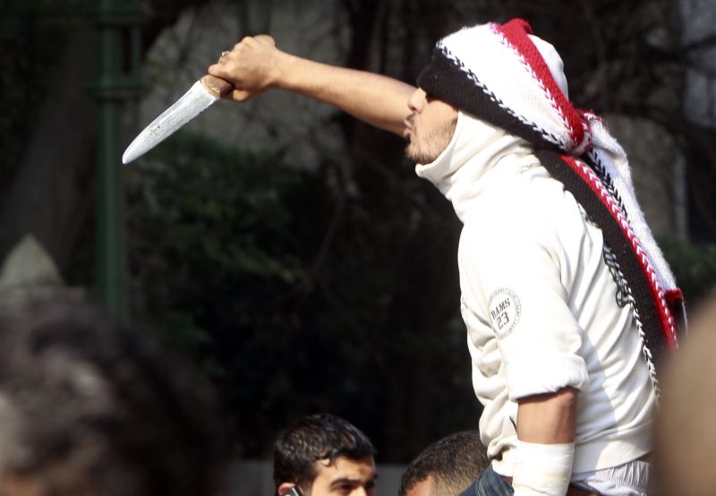 Manifestante segura faca e grita palavras de ordem contra o concelho militar do Egito | Amr Abdallah Dalsh/Reuters