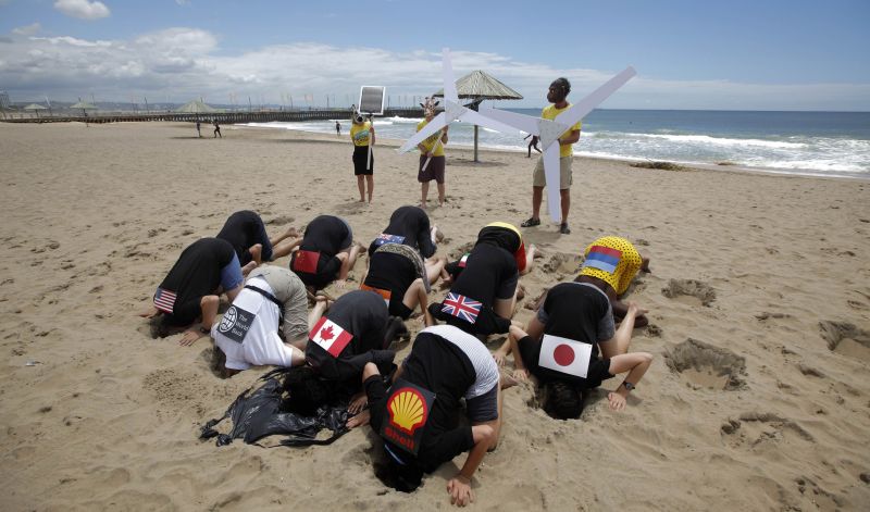 Ambientalistas protestam enterrando suas cabeças na areia em Durban: referência ao comportamento de países e empresas diante das mudanças climáticas | Mike Hutchings/Reuters