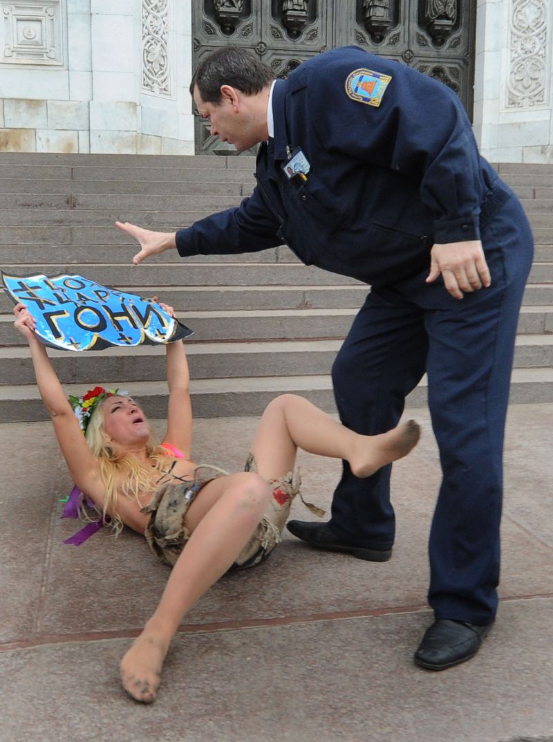 Segurança russo tenta tomar cartaz de feminista durante protesto em Moscou | Alexander Nemenov/AFP