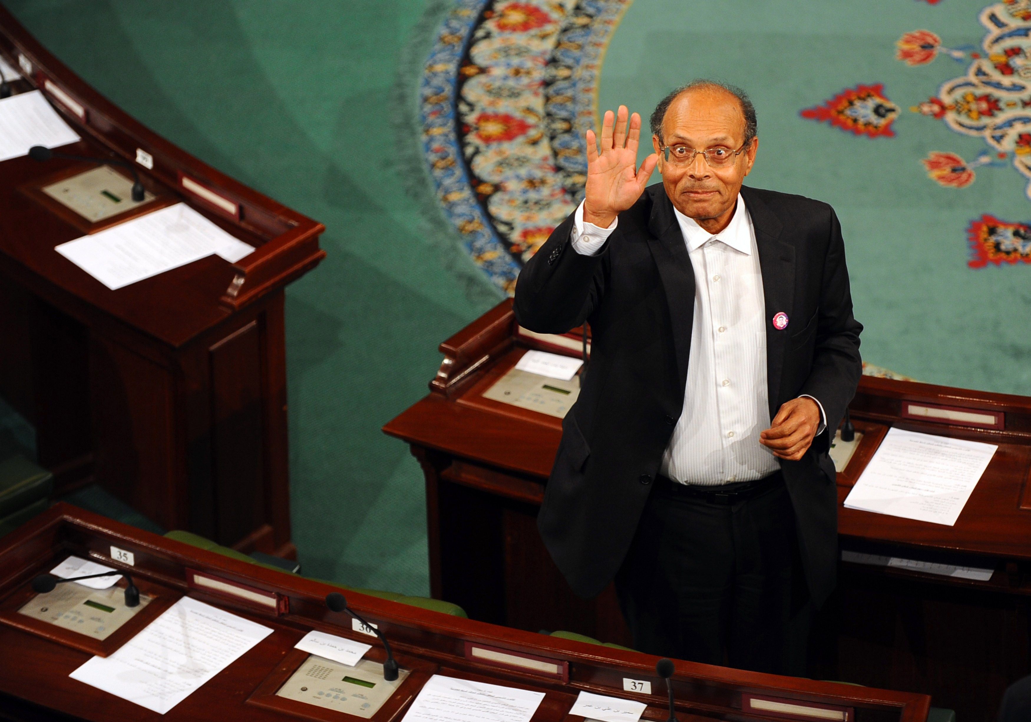 Presidente tunisiano Moncef Marzouki acena para fotógrafos | AFP PHOTO/ FETHI BELAID
