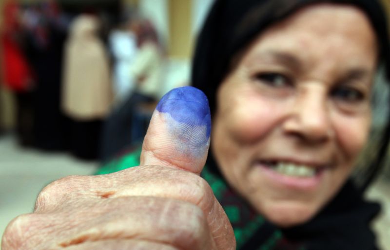Mulher mostra o dedo sujo de tinta depois de votar para o parlamento | Amr Abdallah Dalsh/Reuters
