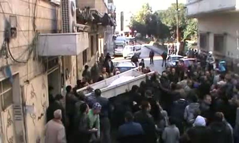 Grupo de pessoas carrega o corpo de um sírio morto pelo governo | YouTube/AFP