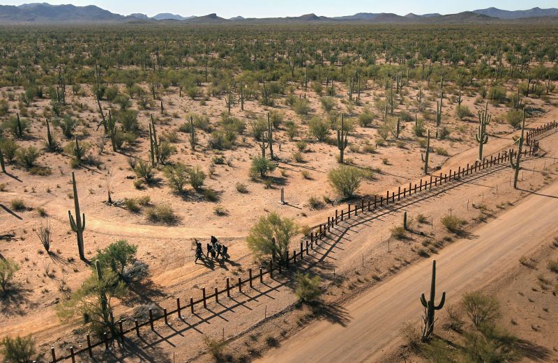 Grupo de jovens mexicanos caminha ao longo da fronteira com os EUA, no deserto de Sonora, estado do Arizona | John Morre/AFP