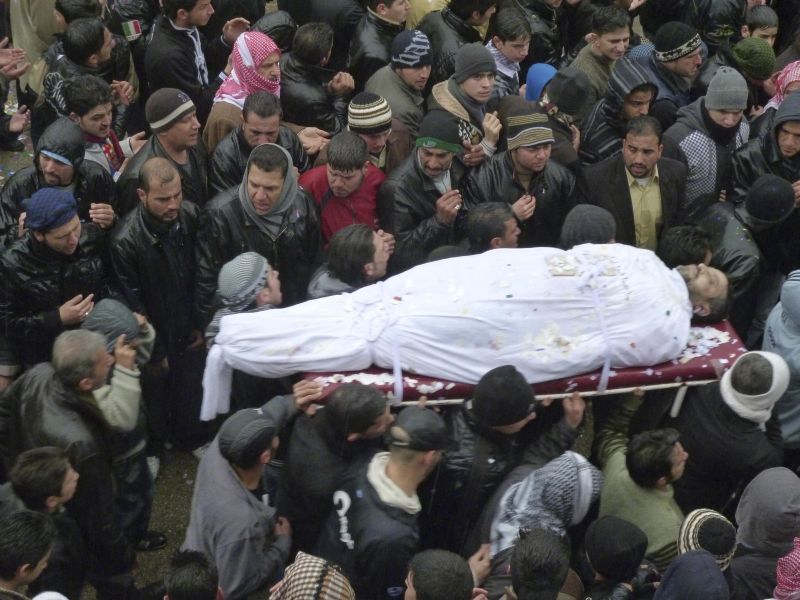 Manifestantes antigoverno carregam corpo durante o funeral de um manifestante morto por forças do governo, em Homs | Handout/Reuters