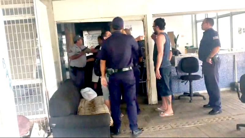 De arma em punho, o sargento André Ferreira (ao fundo) agarra aluno: flagrante na internet levou ao afastamento do PM | Reprodução Youtube