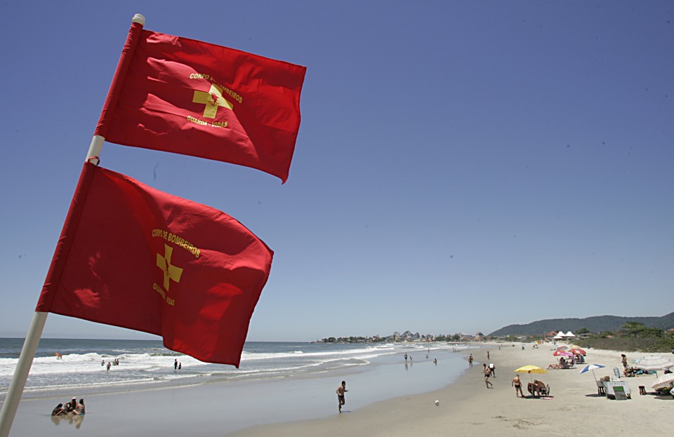 Bandeira dupla vermelha, que indica área interditada, foi colocada em Matinhos na manhã desta terça: veranistas permanecem no mar mesmo com o alerta | Marco André Lima/Gazeta do Povo
