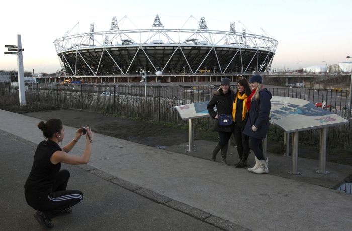 Turistas tiram foto em frente ao Estádio Olimpíco de Londres: Danny Boyle vai dirigir a cerimêonia de abertura dos Jogos | Justin Tallis / AFP