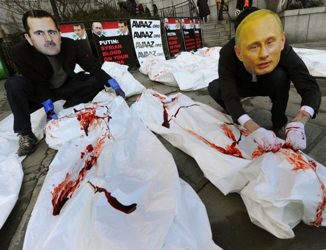 Atores com máscaras de Bashar Assad e Vladimir Putin fazem uma manifestação diante do prédio do Conselho de Segurança da ONU, em Nova York | Timothy A. Clary/AFP