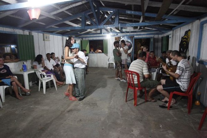 Seu Alcides, de 94 anos, exercita a dança do fandango e ensina às turistas enquanto o grupo toca |