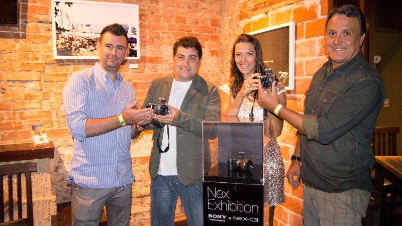 Fábio Purcino (à esq.), gerente de marketing de produtos da Sony Brasil, veio prestigiar o coquetel de lançamento da exposição NEX Exhibition Curitiba, realizado quinta-feira no bar Santa Marta. A mostra conta com fotos produzidas por fotógrafos amadores. Aqui, os escolhidos foram os empresários Gustavo Ferreira (ao centro) e Gustavo Haas (à dir.) e a jornalista Angélica Fenley Belich com a câmera NEX-C3 | Guilherme Wanderley