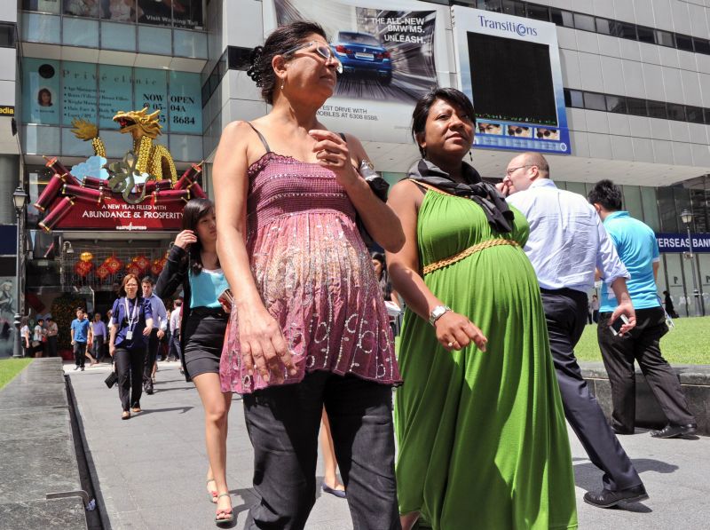Mulheres grávidas desfilam em Singapura. Os chineses mais supersticiosos acreditam que as crianças que nascem no ano do dragão - o símbolo dos antigos imperadores - terão coragem e sabedoria | Roslan Rahman/AFP