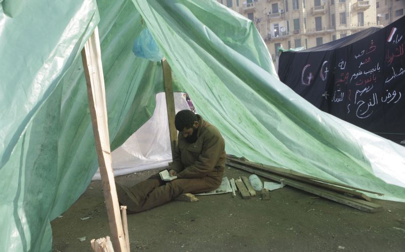 Manifestante lê o Corão em uma tenda na praça protesto um ano depois | Asmaa Waguih/Reuters