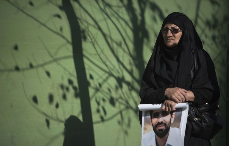Mulher segura poster do cientista nuclear Mostafa Ahmadi-Roshan, morto em atentado | REUTERS/Morteza Nikoubazl