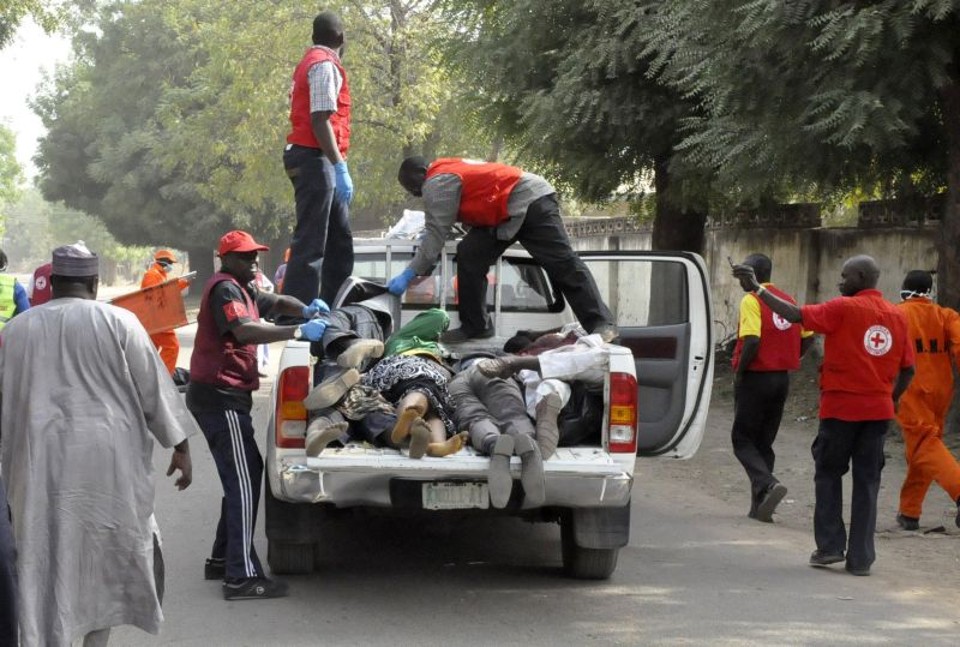 Ataques coordenados e tiroteios deixam ao menos 160 mortos na Nigéria Oficiais da Cruz Vermelha põem corpos em um veículo em Kano, no norte do país | REUTERS/Stringer