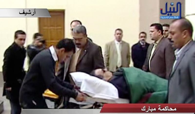Mubarak, 83 anos, foi levado de maca para a sala do tribunal, assim como nas audiências anteriores do processo | AFP PHOTO/DSK