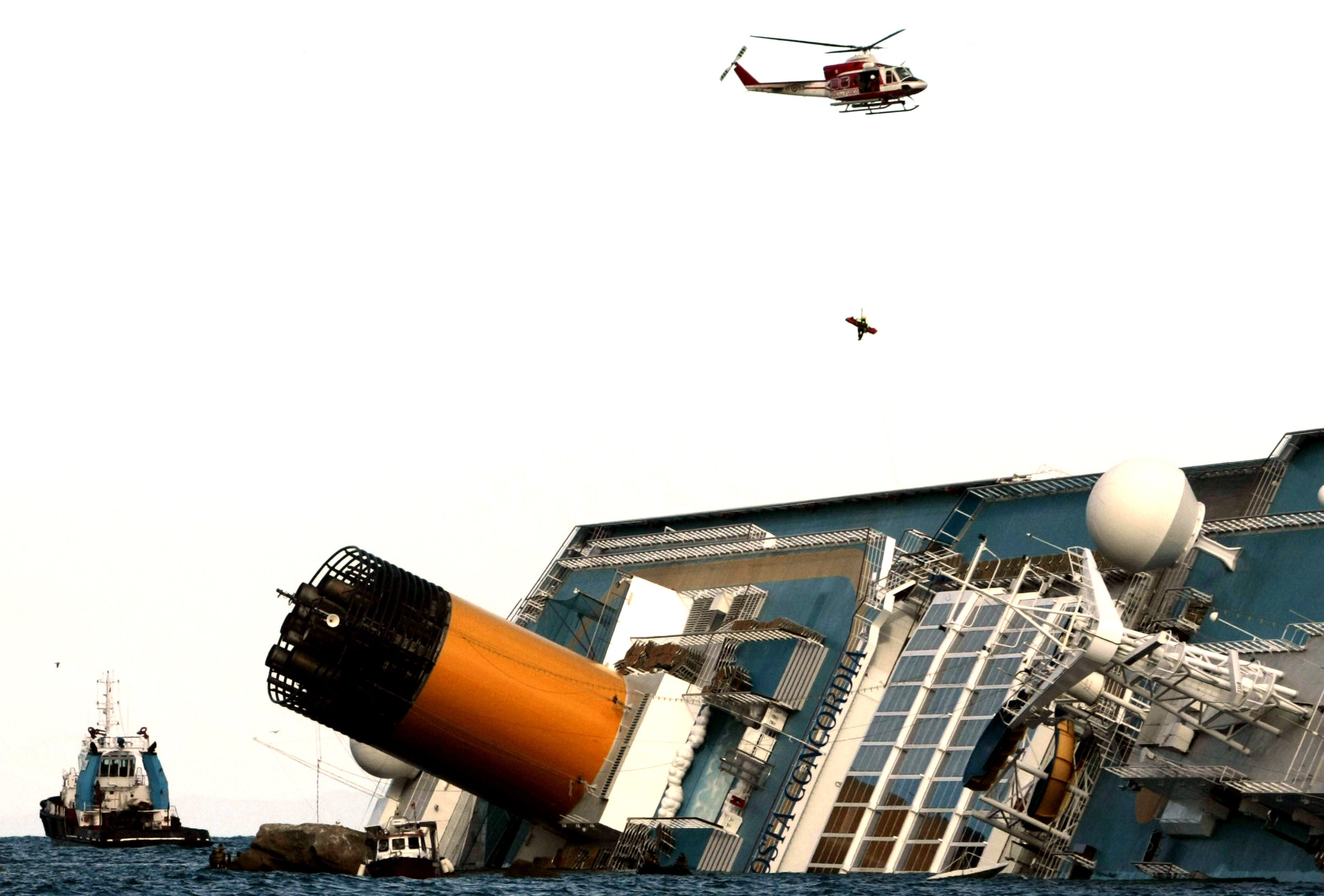 Um helicóptero foi posicionado acima do navio meio submerso para resgatar Marrico Giempietroni, chefe do serviço de bordo do navio Costa Concordia | AFP PHOTO / Filippo MONTEFORTE