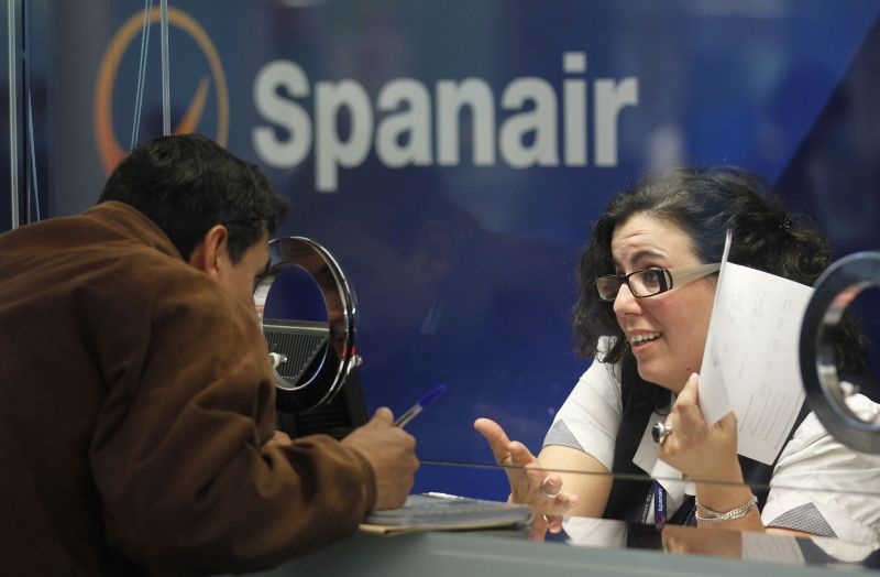 Um homem conversa com a atendente da Spanair no aeroporto de Barcelona | REUTERS/Albert Gea