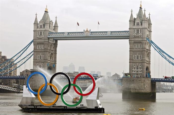 Embarcação com os anéis olimpícos passa pela London Bridge, um dos principais cartões postais de Londres | Kerim Okten / EFE