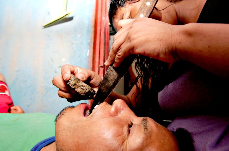 Para afiar os dentes, tribos indígenas do Paraná usam uma faca afiada e uma pedra que, ao bater na lâmina, tira lascas do esmalte | Fotos: Josue Teixeira/Gazeta do Povo