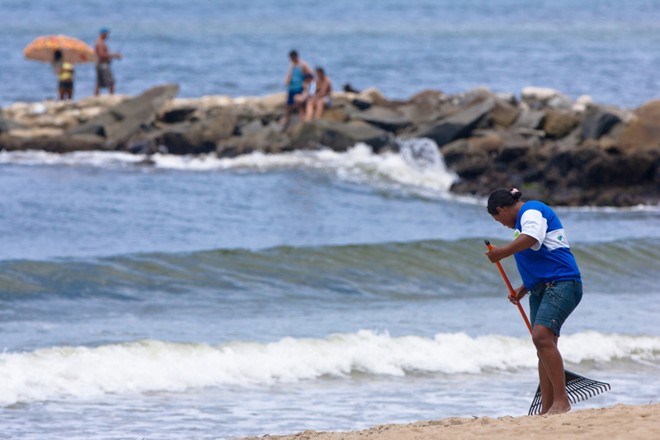 Funcionária faz a limpeza da Praia Mansa, em Caiobá | 