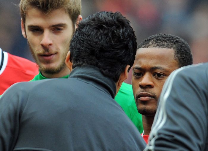 Suárez (de costas) se nega a cumprimentar Evra: ato gerou reclamação do principal patrocinador do Liverpool | Andrew Yates / AFP
