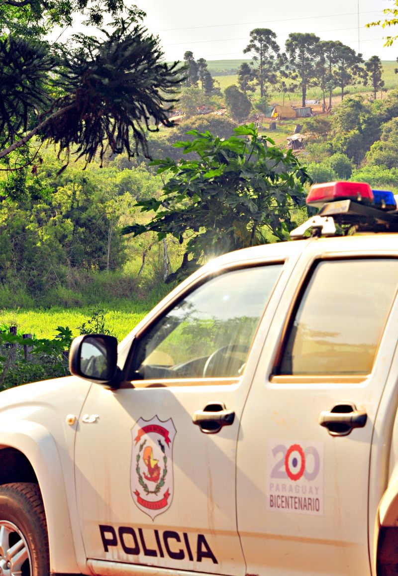Um grupo pequeno de policiais paraguaios acompanha a distância a movimentação no acampamento sem-terra: tensão cresce a cada dia | Marcos Labanca/ Gazeta do Povo
