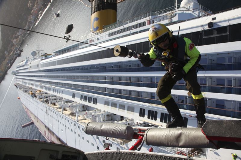 Bombeiro desce por uma corda de um helicóptero no navio Costa Concordia, que afundou na costa da Itália | REUTERS/Vigili del Fuoco/Handout