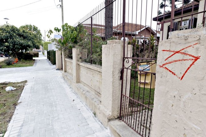 Marcadas para sumir: As desapropriações dos 11 imóveis nos arredores da Arena da Baixada começam a avançar. Pelo menos cinco casas já acertaram o valor da indenização com a prefeitura de Curitiba, que repassará a área ao Atlético em troca de espaço publicitário e de uma futura sede, no local, para a Secretaria Municipal de Esporte. Os imóveis que vão desaparecer estão sendo marcados com tinta vermelha (foto). Segundo informou um dos moradores ouvidos pela Gazeta do Povo, a quantia a ser paga será menor, mas próxima ao valor real do imóvel. 
