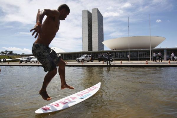 Surfe na Esplanada- Um grupo de cerca de mil manifestantes protestou ontem em Brasília contra a provável aprovação do Código Florestal. Integrantes de diversas entidades ambientalistas surfaram no lago em frente do Congresso Nacional. Nas pranchas e em faixas, havia o slogan Veta Dilma!, num pedido para que a presidente barre a flexibilização da legislação ambiental. Ele ainda gritavam: Arroz, feijão, floresta e educação. Os ambientalistas se opõem até mesmo ao texto aprovado pelo Senado, que o governo considera aceitável. Dilma já sinalizou que, se ele for mantido da maneira como passou no Senado, não será vetado | Ueslei Marcelino/Reuters