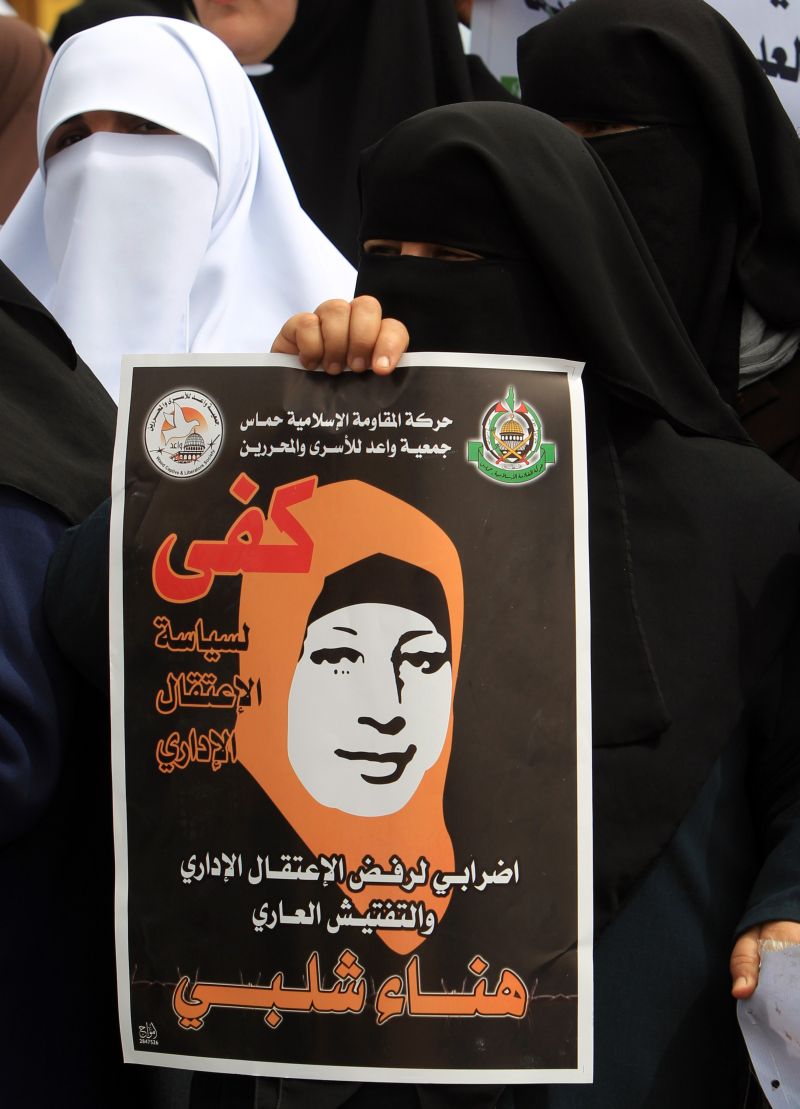 Palestina exibe cartaz de protesto contra a prisão administrativa de Hanaa Chalabi, que está em greve de fome | Mahmud Hams/AFP