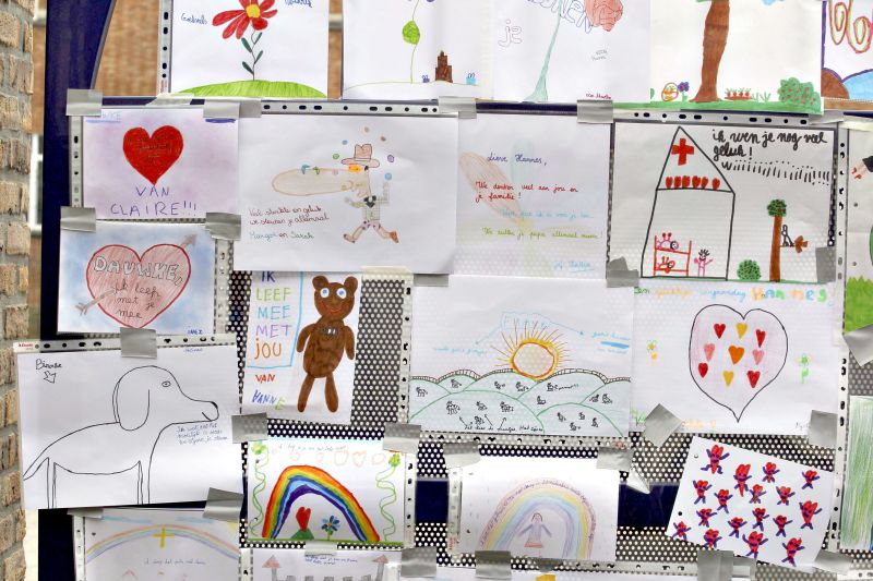 Notas e desenhos de condolência fixados em muro da escola Sint Lambertus, na Bélgica. Maioria das crianças mortas eram belgas | Yves Herman/Reuters