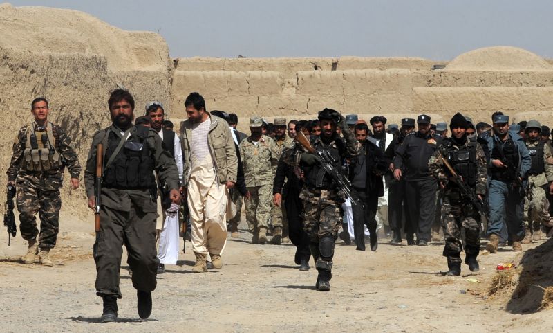 Delegação afegã caminha com locais após cerimônia em mesquita em homenagem às vítimas do massacre em Kandahar | AFP PHOTO/ JANGIR