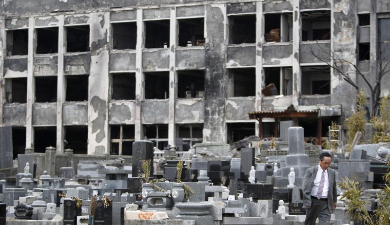Homem passa por escola, destruída pelo terremoto e tsunami em março de 2011, em Kadonowaki | REUTERS/Toru Hanai