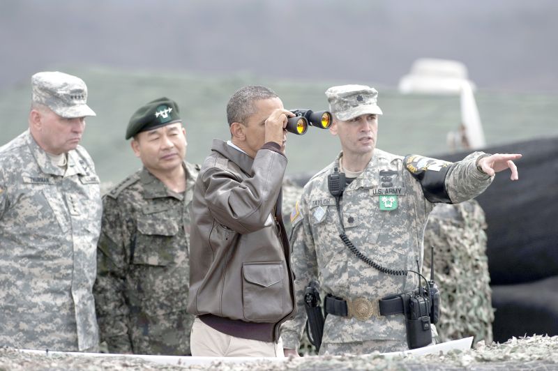 Na fronteira entre as duas Coreias, Obama usa binóculos para olhar a região norte | Saul Loeb/AFP