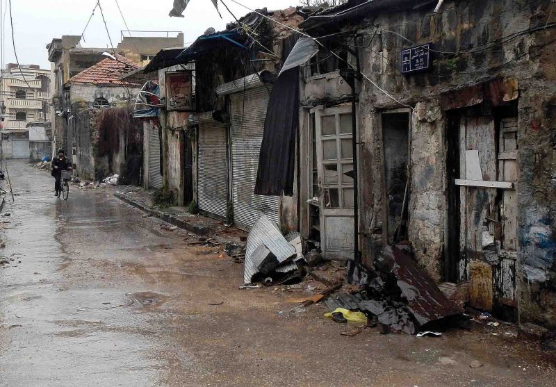 Homem anda de bicicleta em rua de Homs, na Síria, com vários prédios destruídos durante os conflitos entre opositores e as forças de segurança | Karam Karam/Reuters