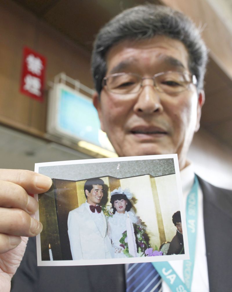 Shigemi Yoshida mostra foto de seu casamento. A esposa morreu na tragédia | Toru Hanai/Reuters
