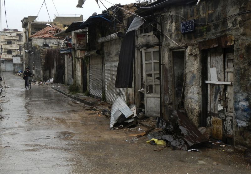 Homem anda de bicicleta por ciade de Homs, massacrada por ataques de militares | REUTERS/Karam Karam